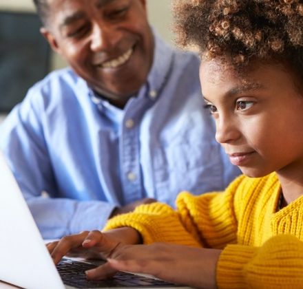 A man and a young girl using a computer